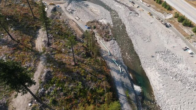 Construction of the TMX oil and gas pipeline in British Columbia Canada. Building an oil pipeline near a river.