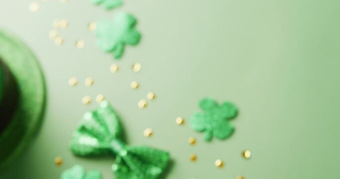 Video of saint patricks day green shamrock, hat and bow tie with copy space on green background