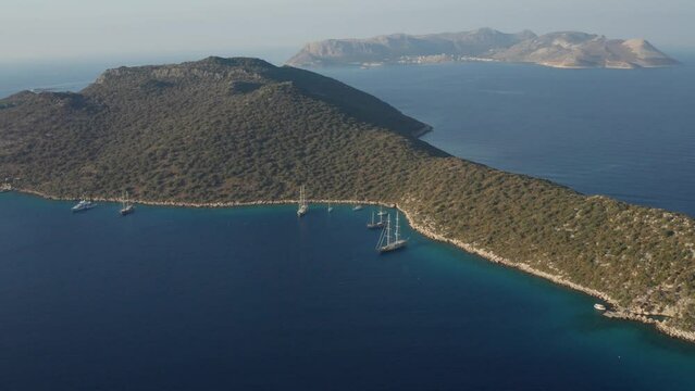 Aerial view of Mediterranean bay of Kas in Turkey. Panoramic view in showing bay, yachts, sailing boats, and surrounding mountains landscape including Greek island of Kastellorizo