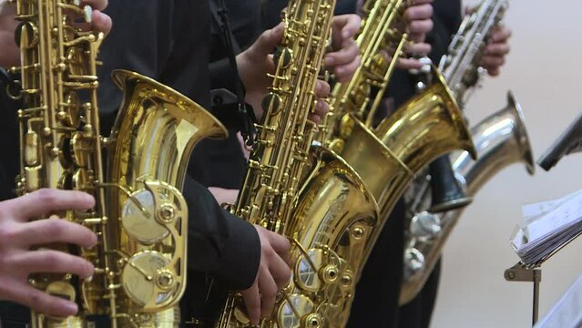 Jazz musicians play the saxophone, close-up.