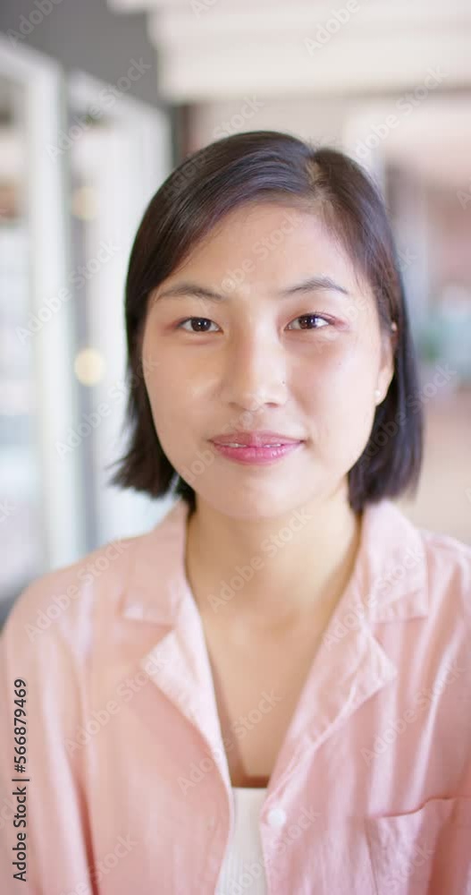 Poster Vertical video portrait of asian businesswoman opening eyes and smiling in office, slow motion