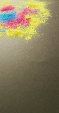 Vertical video of close up of colourful powders on grey background, with copy space