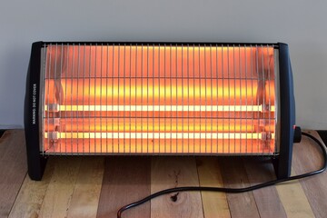 A electric bar heater, close up. switched on and radiating heat., illustrating power bills, expense...