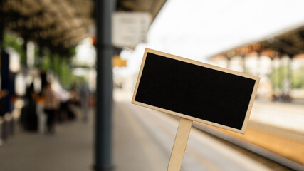 Empty mockup template Blackboard label against defocused background railway station with...