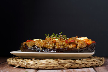 eggplants stuffed with meat and vegetables on a white plate on a wooden table