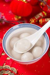 Tang Yuan(sweet dumplings balls) in a bowl.traditional cuisine food on red background.