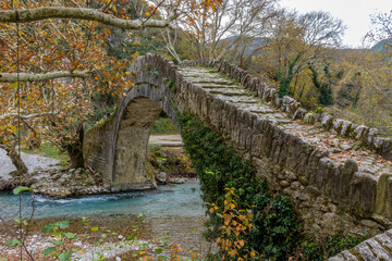 Old stone bridge in Klidonia  during fall season.  This arch bridge was built in 1853 and it is...