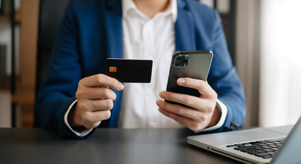 Man using smart phone for mobile payments online shopping,omni channel,sitting on table,virtual icons graphics interface screen