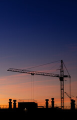 Construction high-rise crane on the background of the sunset sky