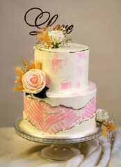 Festive wedding bunk cake decorated with fresh flowers on a dark background