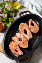 Pieces of fresh salmon fillet with spices on a grill pan. Seafood, culinary background.