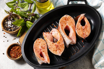 Pieces of fresh salmon fillet with spices on a grill pan. Seafood, culinary background.