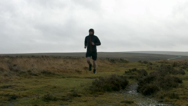 Runner Keeping Healthy Running Past Camera Training for Marathon in Cold Conditions in Moorland Countryside UK 4K
