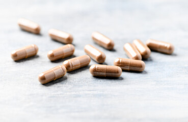Guarana capsules. Bright wooden background. Close up. Copy space. 	
