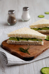 Homemade English Cucumber Sandwiches on a rustic wooden board, side view.
