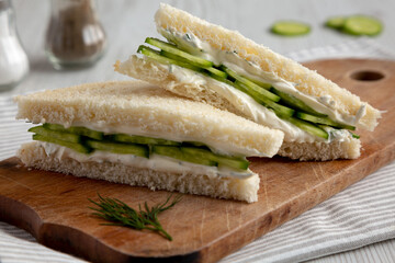Homemade English Cucumber Sandwiches on a rustic wooden board, side view. Close-up.