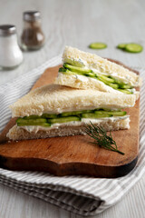 Homemade English Cucumber Sandwiches on a rustic wooden board, side view. Close-up.