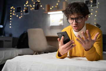 Upset frustrated male student reading bad news on message, having problem with device or Internet...