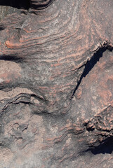 The wavy and bumpy brown rock background has been formed by the erosion of the flowing water for a long time, resulting in a beautiful pattern along the flowing water.