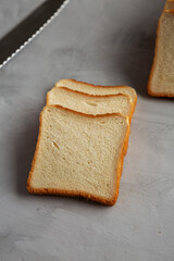 Sliced Whole Wheat White Bread on a gray background, side view.