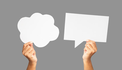Close-up of hands holding a white speech bubbles against a gray background - Powered by Adobe