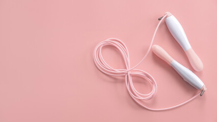 Fitness and healthy sport concept. Pink jumping rope on a pastel pink background. Top view, flat lay, copy space