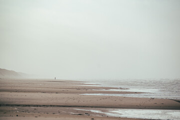 ein einzelner Mensch am weitl&auml;ufigen Strand in D&auml;nemark