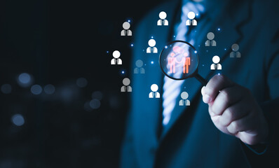 bussinessman holding magnifier glass focus to manager icon which is among staff icons for human development recruitment leadership and customer target group concept. HRM or Human Resource Management.