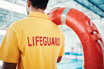 Lifeguard, man and swimming pool safety at indoor facility for training, swim and exercise. Pool,...