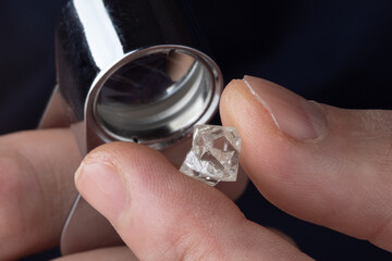 Rough diamond close up in the process of evaluation by diamond expert. High quality photo