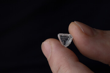 Rough diamond close up in the process of evaluation by diamond expert. High quality photo