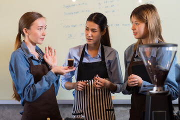 Group of young barista women discuss and working at the coffee shop. Group of female waitress training or meeting at coffee shop