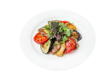 Grilled vegetables with meat on a white plate. Baked slices of tomatoes, eggplant and potatoes. Close-up. Isolated on white background.