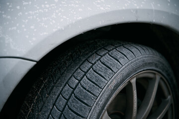 Close-up of car wheels rubber tires in winter snow. Concept of transportation and safety during the...