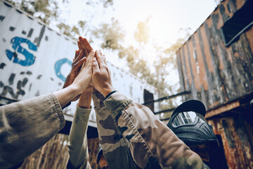 Fototapeta premium Paintball, team and high five for celebration, achievement and victory while on vacation, playful or fun. People, group and gesture for accomplishment, partnership or collaboration to win and success