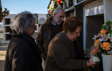 Obraz premium Group of family, mother, son and daughter mourning in cemetery