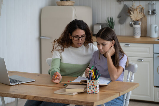 Young Mother Teaching Teen Girl Daughter At Home, Mom Helping Sad Frustrated Kid With Difficult School Task, Supporting Child In Remote Learning. Woman Freelancer Balancing Parenting And Remote Work