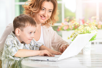 nice mother and son using modern laptop