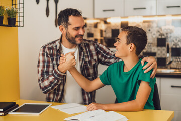 Father is helping his son with learning. They are doing homework together.