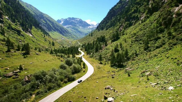 Drone Switzerland 4k. mountain pass winding roads in Swiss Alps. Road trip in valley in summer.