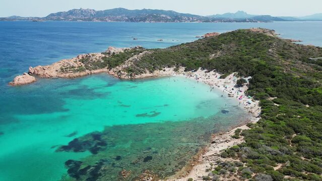 La Maddalena Island, Caprera, Sardinia - Tourist People Swim and Relax at Cala Andreani Beach in Blue Bay - Aerial 4k