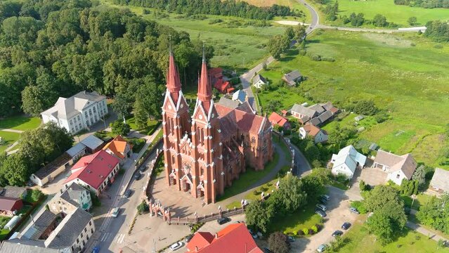 Majestic tall church in small township of Sveksna, Lithuania, aerial orbit view