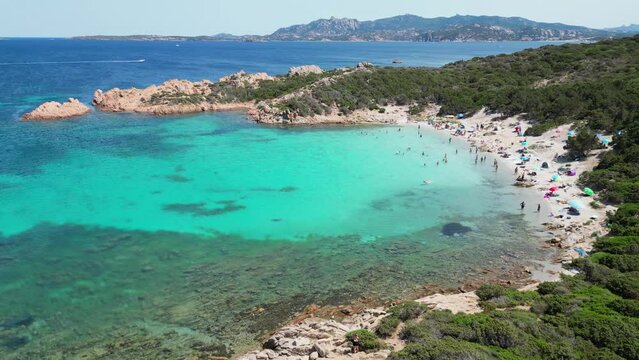 La Maddalena Island, Caprera, Sardinia - Tourist People Swim and Relax at Cala Andreani Beach and Blue Bay - Aerial 4k Circling