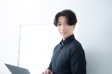 Man holding computer and looking at camera 