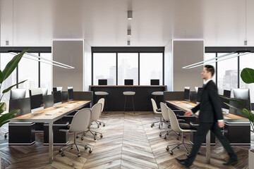 Blurry european businessman walking in modern wooden coworking office interior with window and city view, daylight, furniture and equipment.