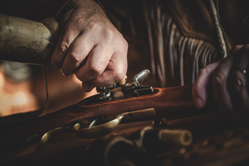 mano che lavora con un fucile d'epoca in stile western dai colori caldi e luce naturale soffusa