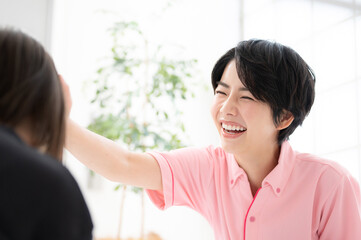 頭をなでる学童や保育士、介護士のイメージ