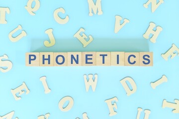 Study phonetics in linguistics concept. Wooden blocks word typography flat lay in blue background.
