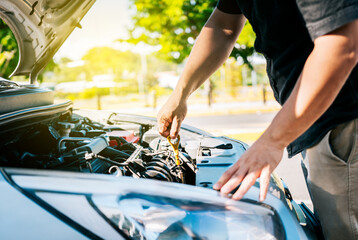 Driver hand inspecting car oil level. Man hand checking oil to car with copy space. People hand...