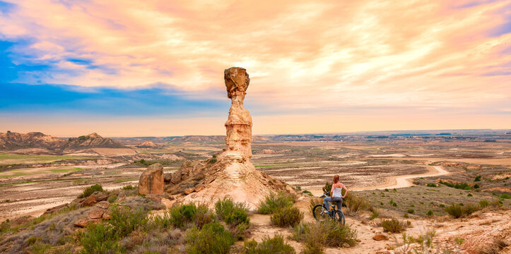 Monegros desert sandstone and woman on mountain bike- Spain